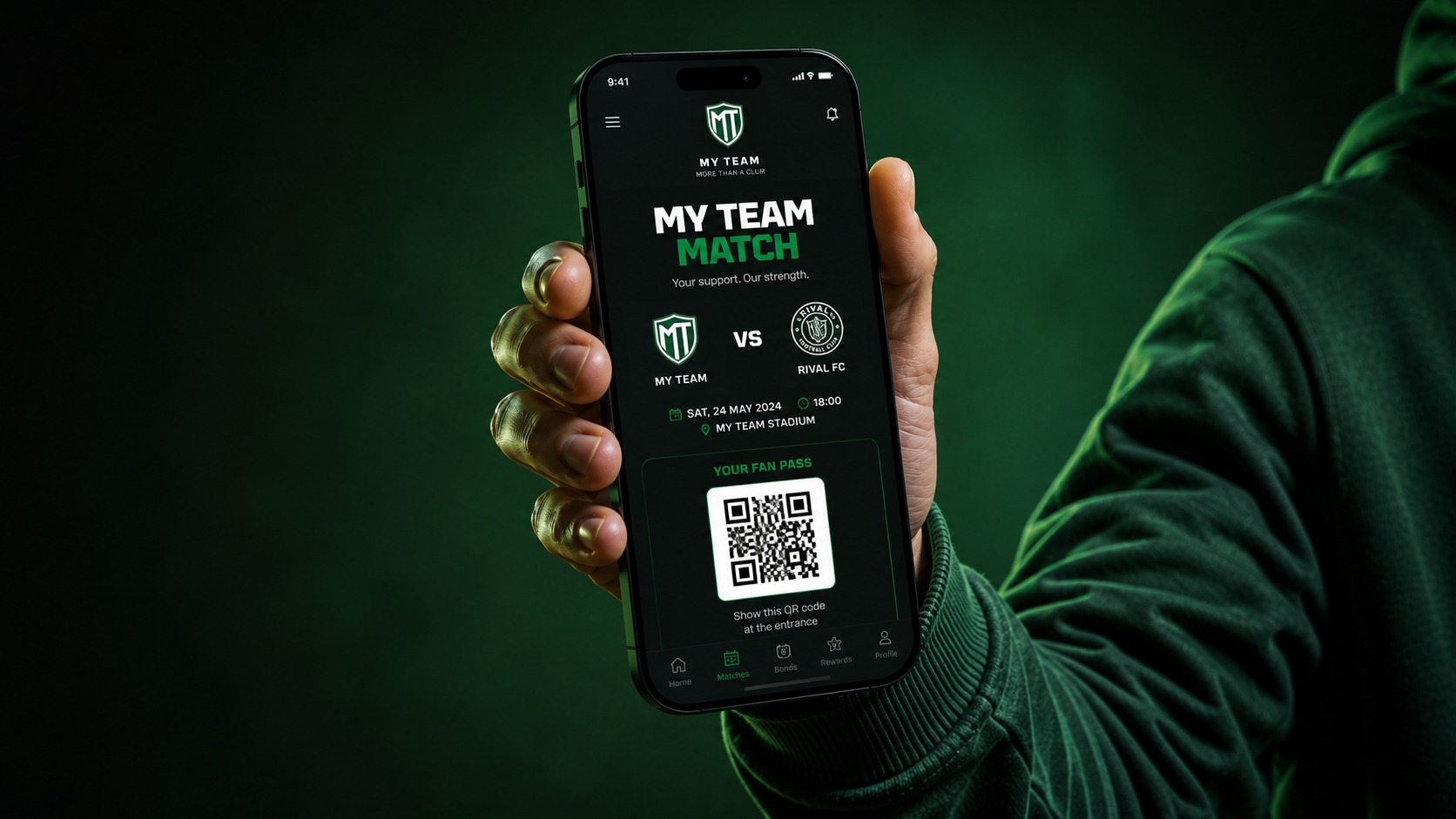 A football supporter holding up a phone showing the MY TEAM fan bonds app